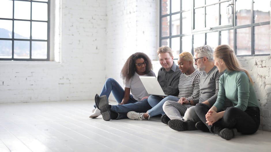 Diverse team collaborating around a laptop in a modern office