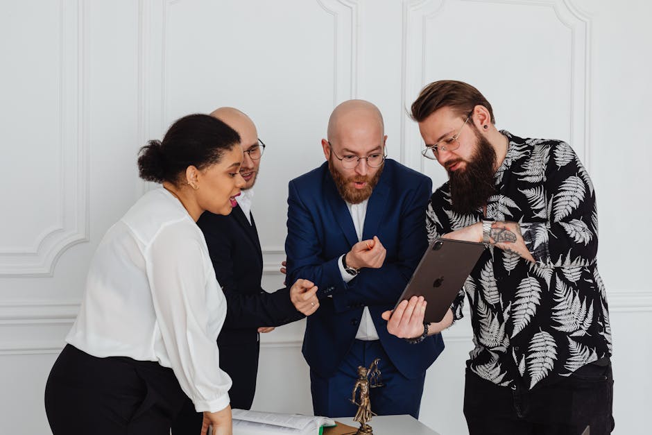 Diverse business team gathered around a tablet in a modern office, discussing enterprise mobile app strategy