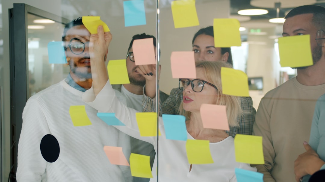 Team brainstorming with sticky notes on glass wall