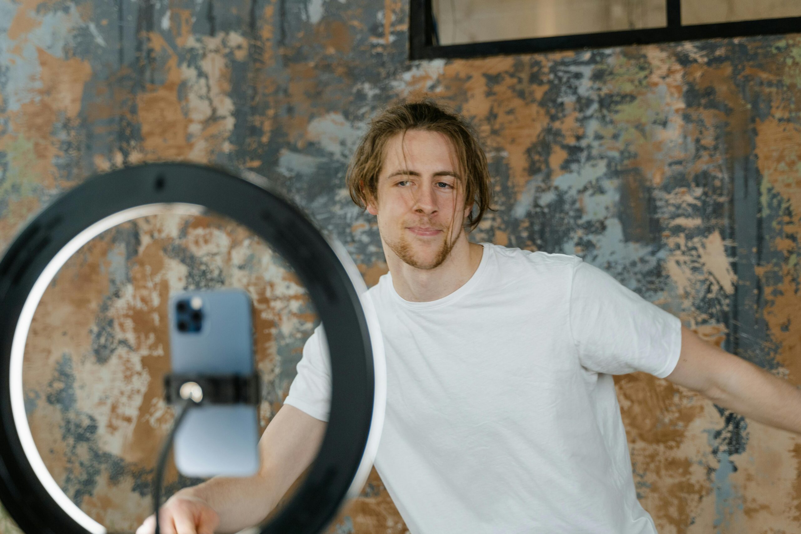 Content creator filming video with smartphone and ring light