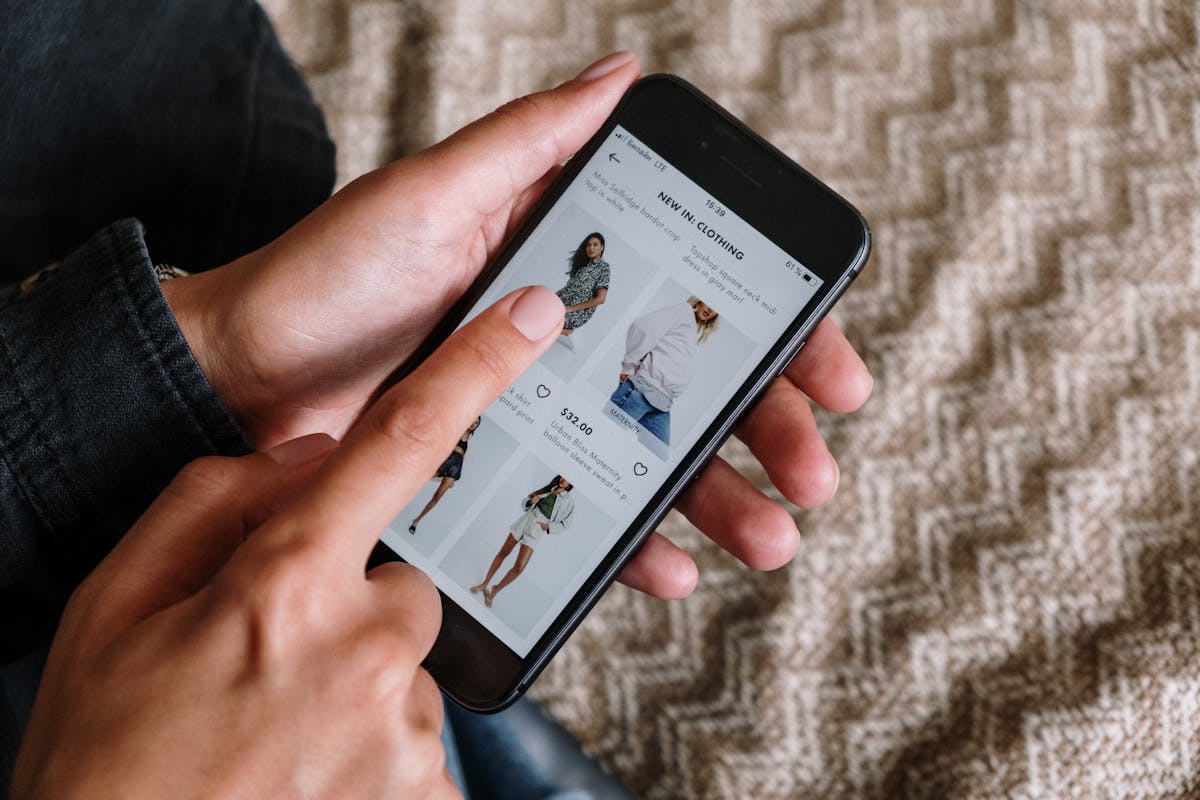 Person browsing clothing on a smartphone, showcasing mobile shopping experience